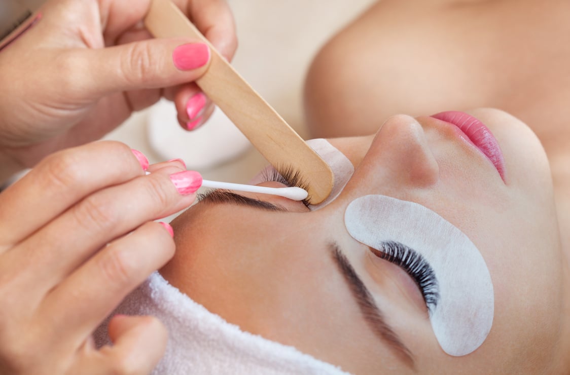 Eyelash removal procedure close up. Beautiful Woman with long lashes in a beauty salon